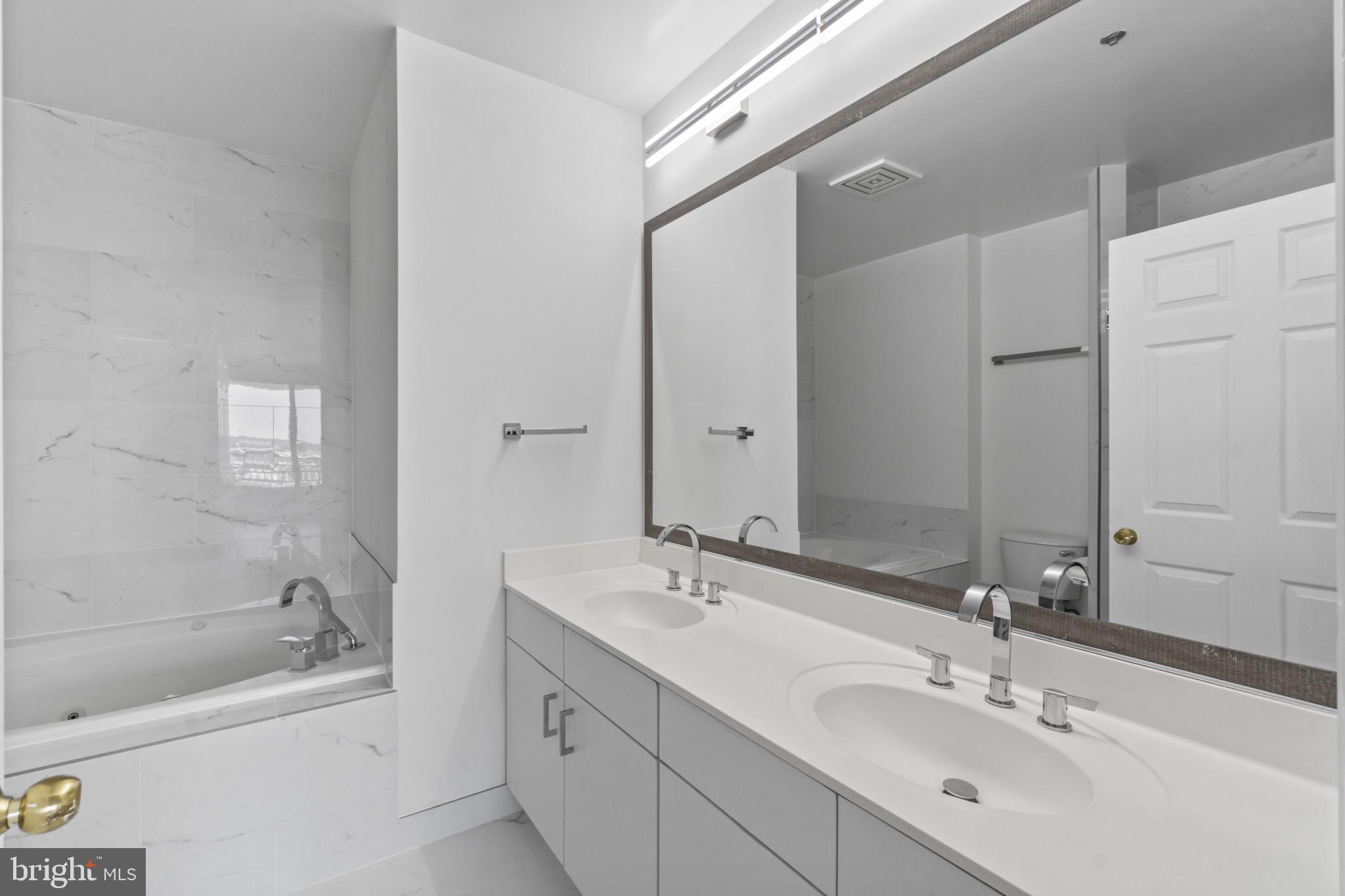 100 Harborview Drive, Unit 1312 Baltimore, MD 21230 - Photo 26 of 37 a bathroom with a bathtub shower sink vanity and mirror