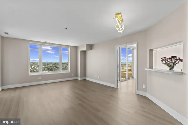 a kitchen with stainless steel appliances kitchen island granite countertop a refrigerator oven a sink dishwasher and white cabinets with wooden floor