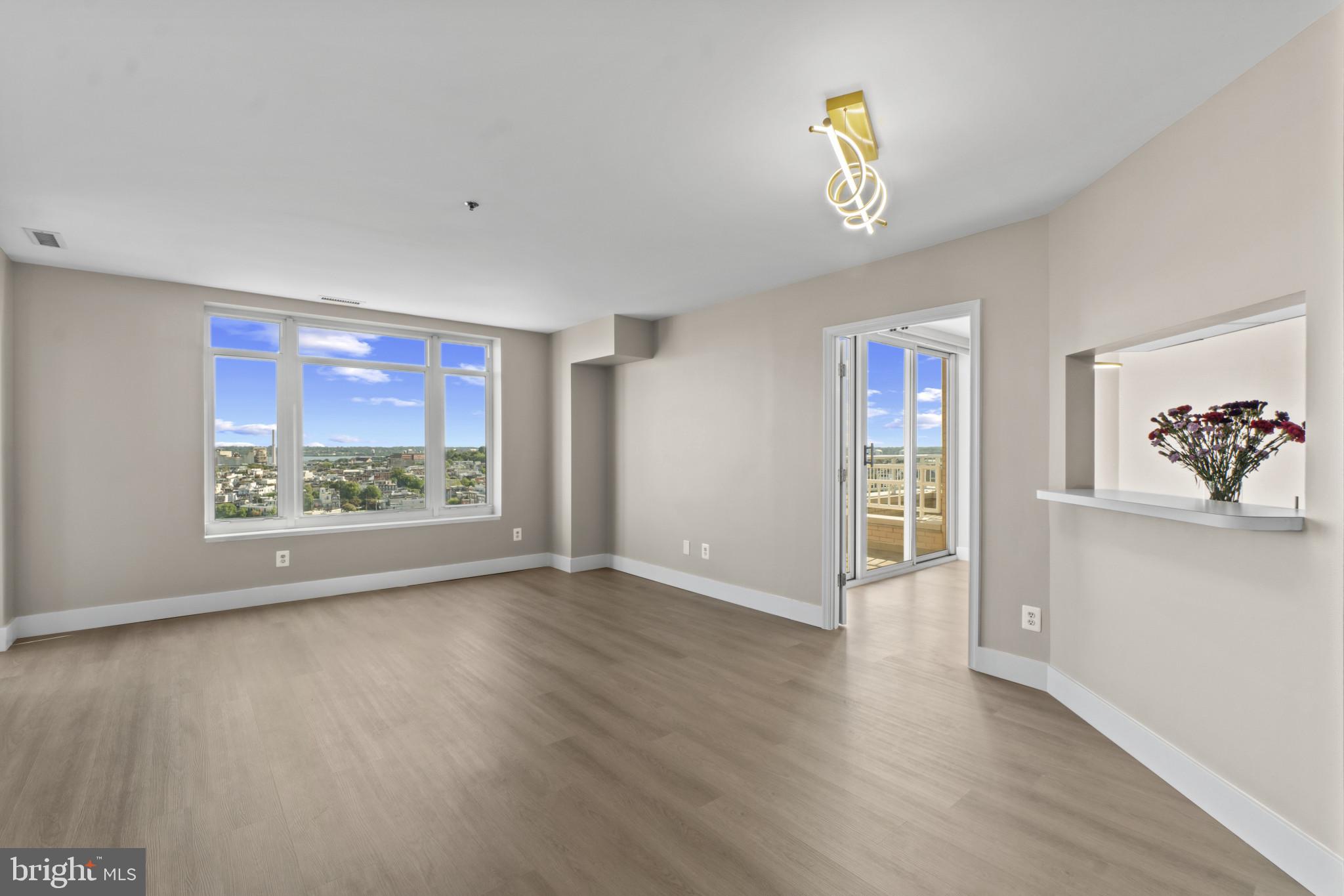 100 Harborview Drive, Unit 1312 Baltimore, MD 21230 - Photo 7 of 37 a view of an empty room with a window and wooden floor
