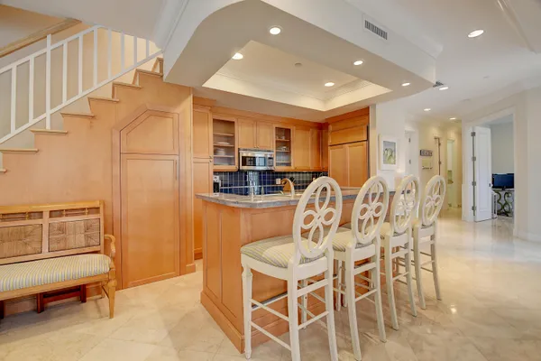 a kitchen with stainless steel appliances kitchen island granite countertop a refrigerator and cabinets
