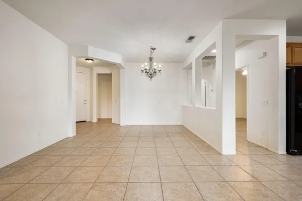 wooden floor in an empty room with a chandelier