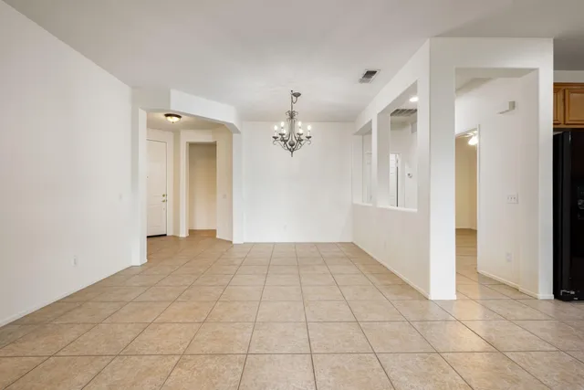 wooden floor in an empty room with a chandelier