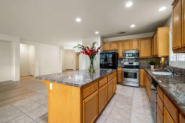 a kitchen with stainless steel appliances granite countertop a sink counter space cabinets and a large window