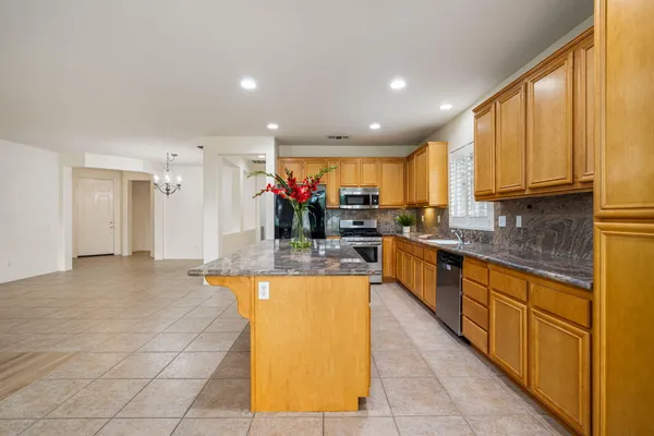 a large kitchen with kitchen island granite countertop a large counter top stainless steel appliances and cabinets