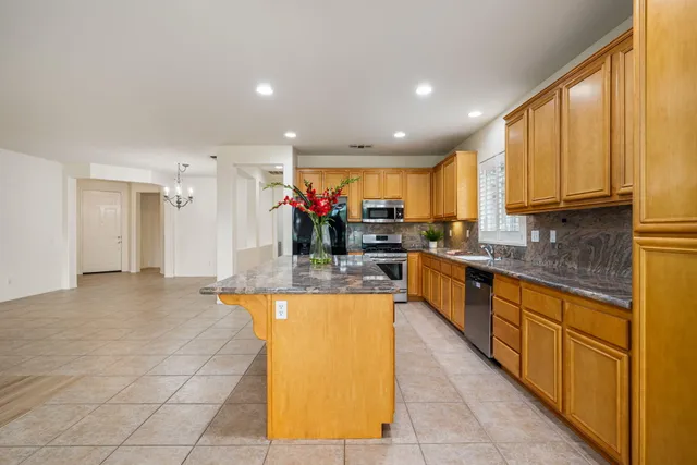 a large kitchen with kitchen island granite countertop a large counter top stainless steel appliances and cabinets