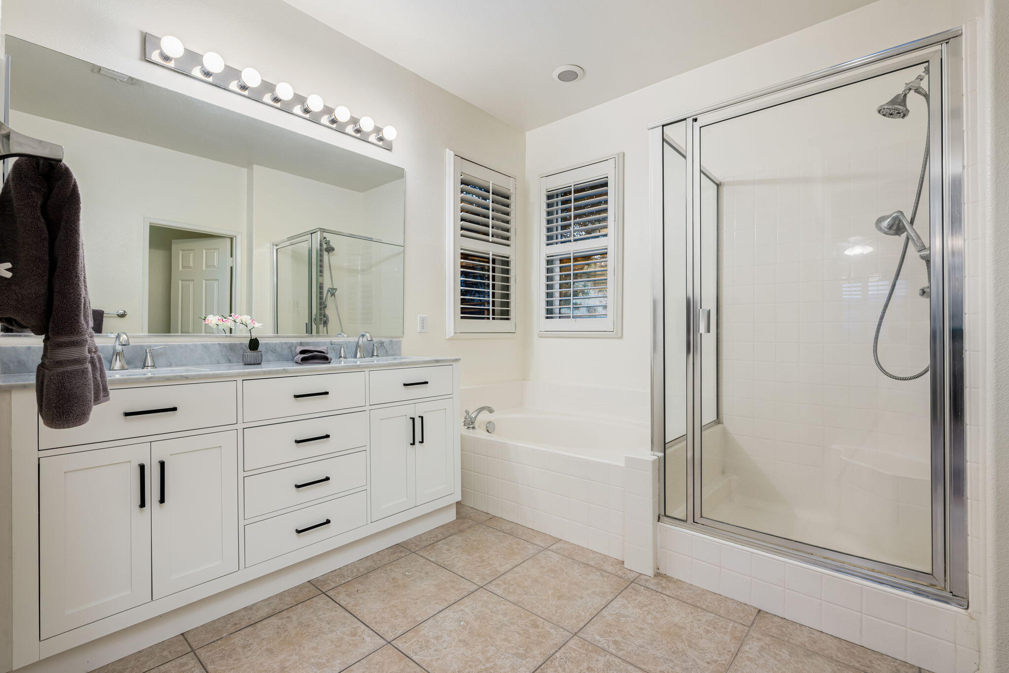 82631 Redford Way Indio, CA 92201 - Photo 28 of 43 a bathroom with a double vanity sink a mirror a shower and a bathtub