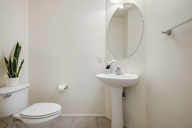a bathroom with a toilet a sink and a mirror