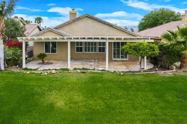 a view of a house with a yard and sitting area