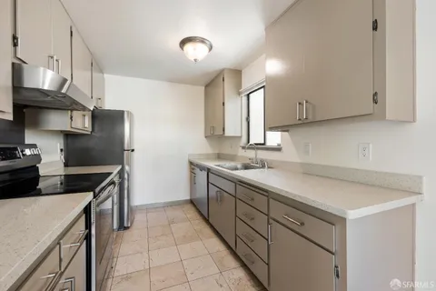 a kitchen with a sink dishwasher a stove and a refrigerator with wooden cabinets
