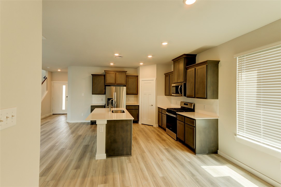 760 Double Mountain Road College Station, TX 77845 - Photo 8 of 26 a kitchen with stainless steel appliances kitchen island granite countertop a stove top oven a sink and a refrigerator