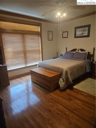 a spacious bedroom with a bed and wooden floor