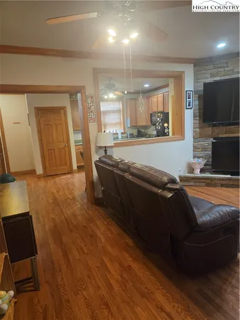 a living room with couches and a flat screen tv with wooden floor