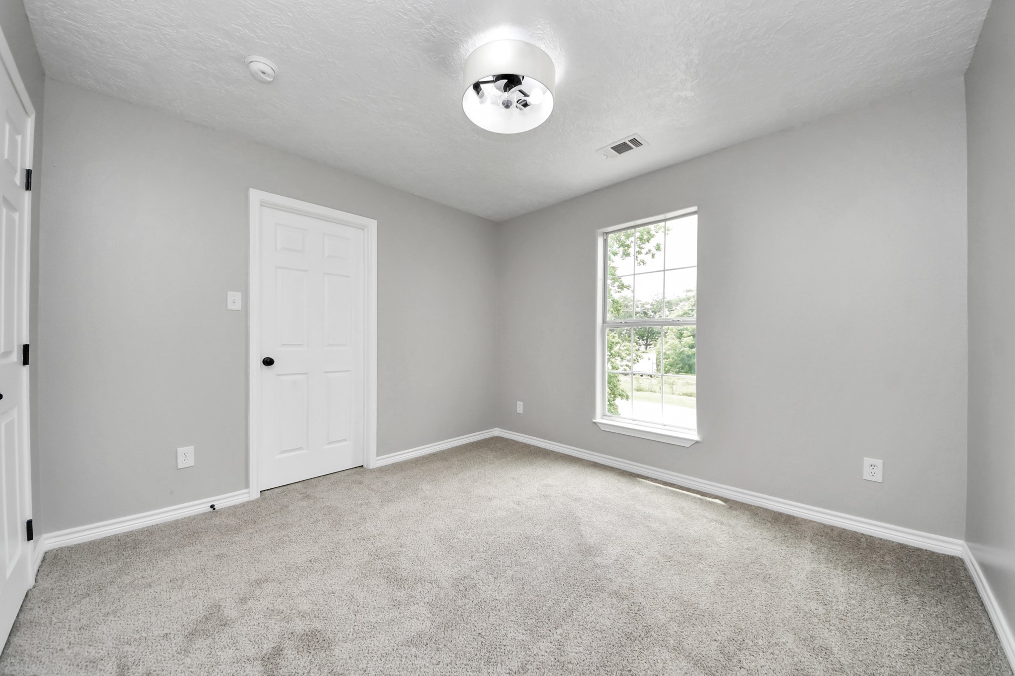 1105 East Kyle Road Clute, TX 77531 - Photo 34 of 44 The other secondary bedroom has neutral gray walls, a plush carpet, and a large window providing natural light. The ceiling has a modern light fixture, and the space offers a cozy, clean feel, ideal for a bedroom or office.