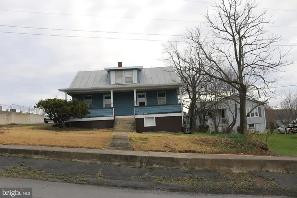 a view of a house with a yard and large tree