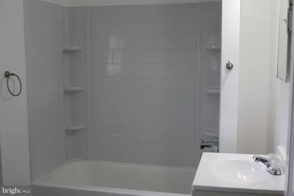 a bath tub sitting next to a white sink