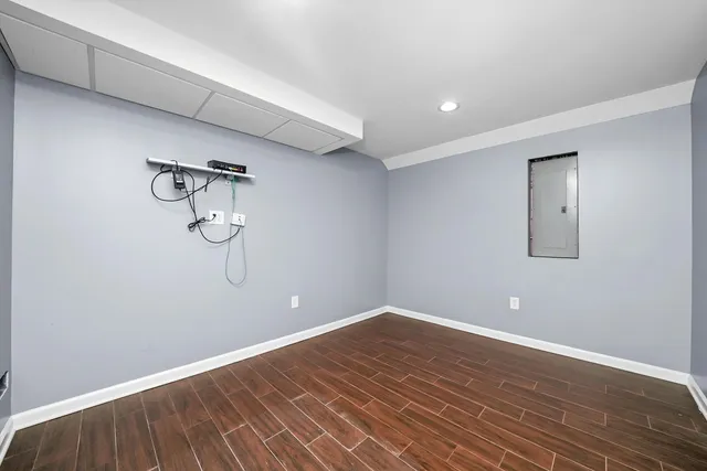 an empty room with wooden floor and a ceiling fan