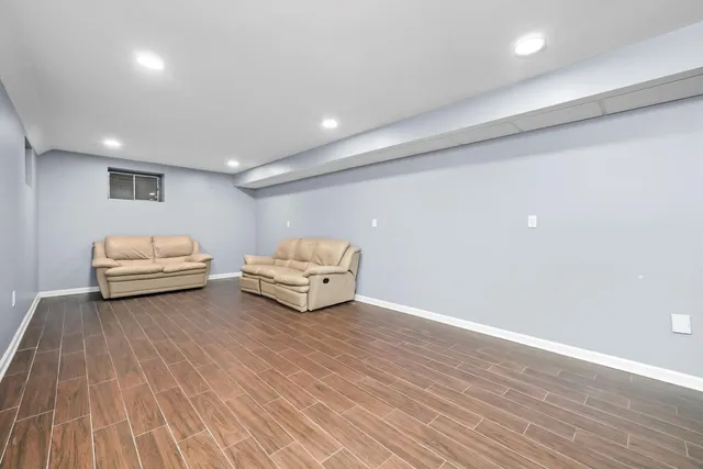 a view of an empty room with wooden floor stairs and a chandelier