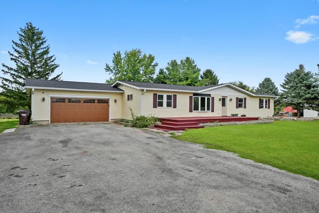 a view of a house with a wooden deck and a big yard