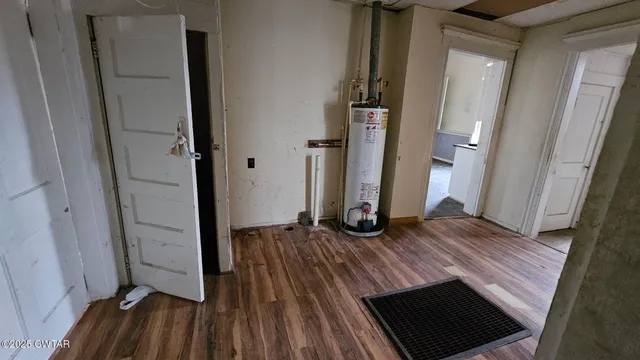 an empty room with wooden floor and entrance