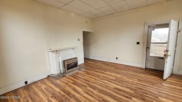 a view of a livingroom with wooden floor and a fireplace