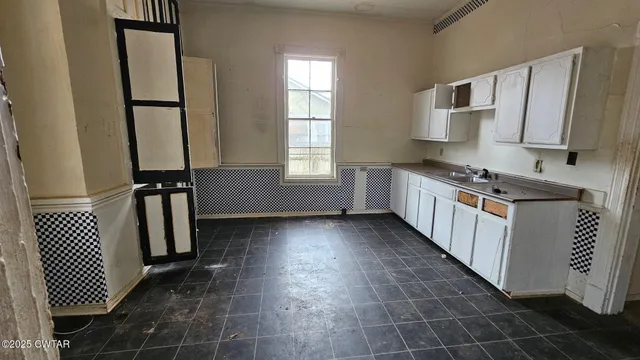 a kitchen with a sink a stove and cabinets