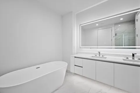 a bathroom with a tub sink and mirror