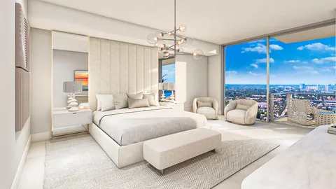 a bedroom with a bed couch chandelier and large window