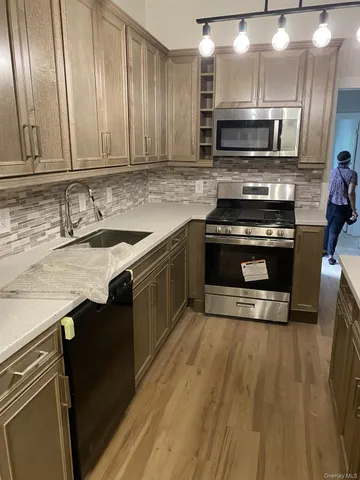 a kitchen with stainless steel appliances a stove a sink and a microwave