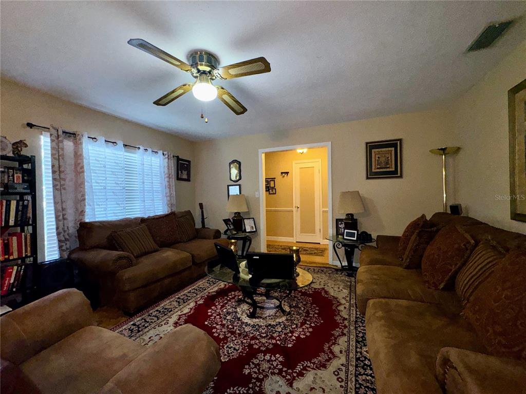2908 Forest Circle Seffner, FL 33584 - Photo 11 of 46 a living room with furniture ceiling fan and a rug