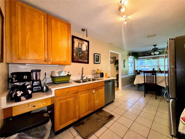 a kitchen with stainless steel appliances kitchen island granite countertop a refrigerator a stove top oven and a sink with dishwasher