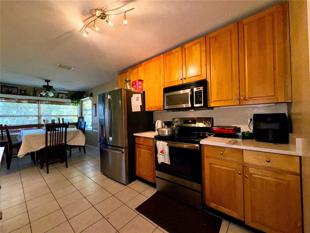 2908 Forest Circle Seffner, FL 33584 - Photo 14 of 46 a kitchen with stainless steel appliances kitchen island granite countertop a refrigerator a stove top oven and a sink with dishwasher