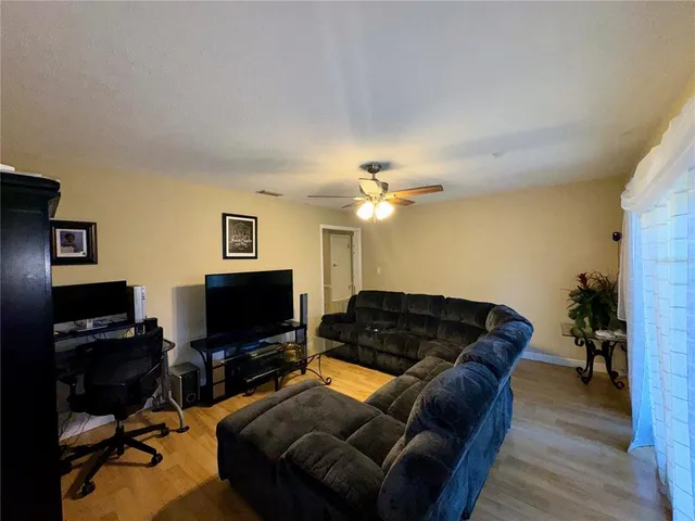 a black leather couch in a living room with a chandelier