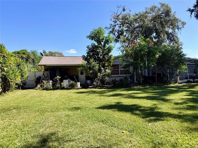 a view of a swimming pool with lawn chairs under an umbrella
