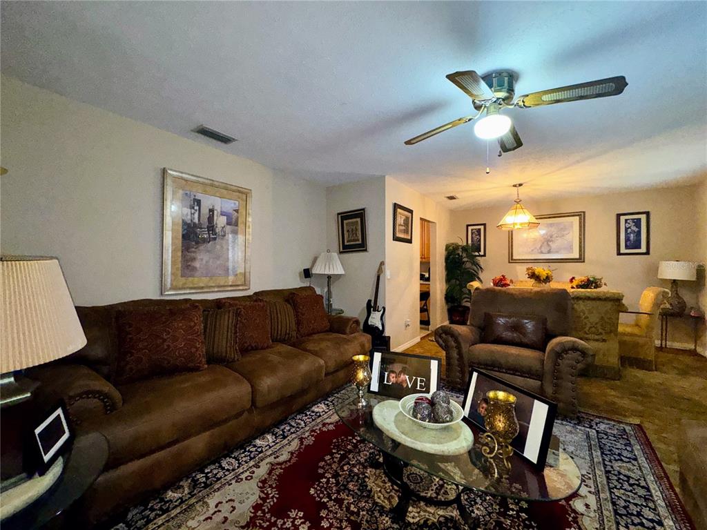 2908 Forest Circle Seffner, FL 33584 - Photo 7 of 46 a living room with furniture a rug and a chandelier