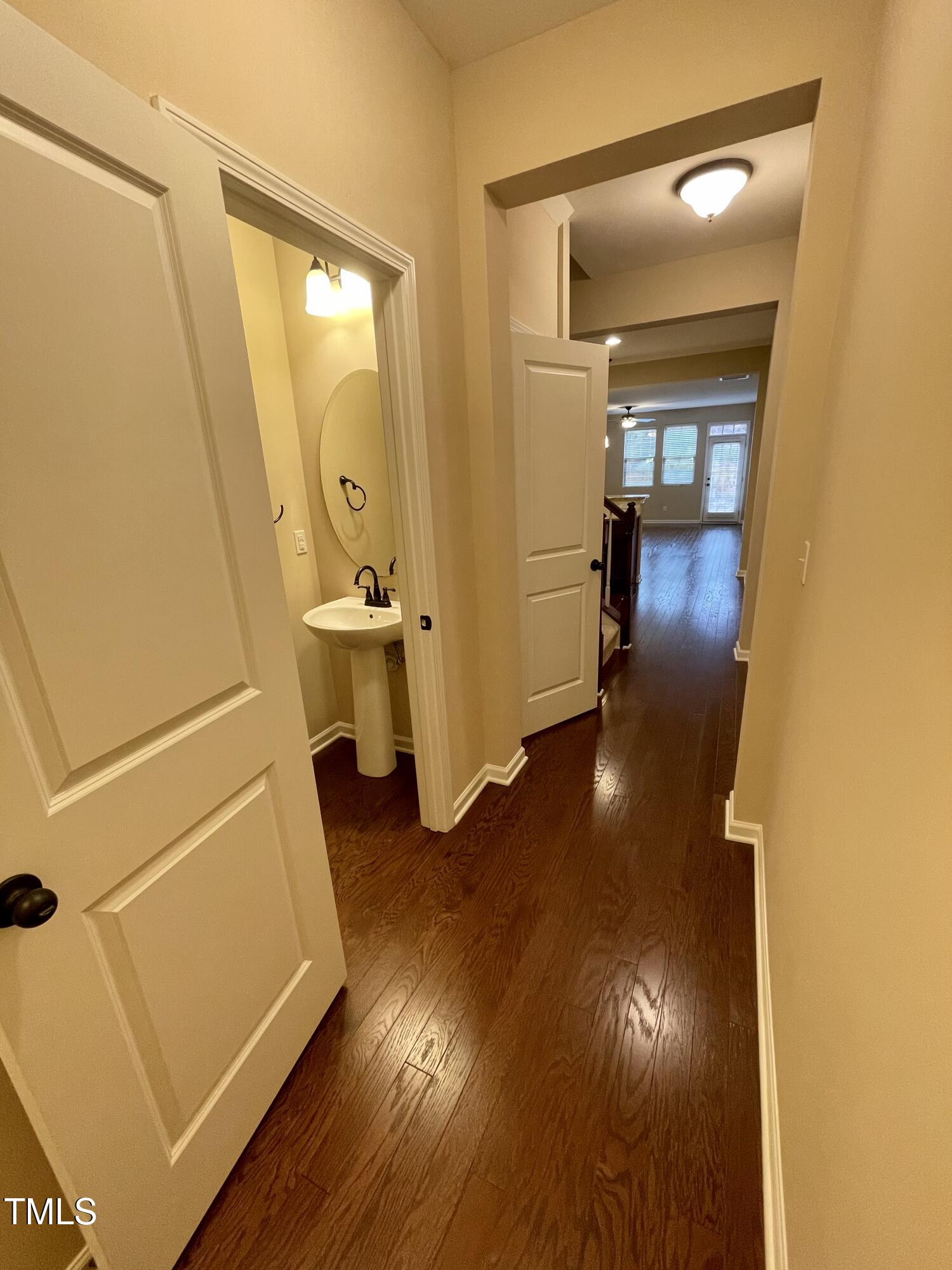 2452 Baslow Drive Apex, NC 27539 - Photo 2 of 25 a view of a hallway with wooden floor and a bathroom