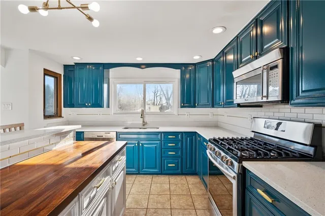 a kitchen with stainless steel appliances granite countertop a sink stove and cabinets