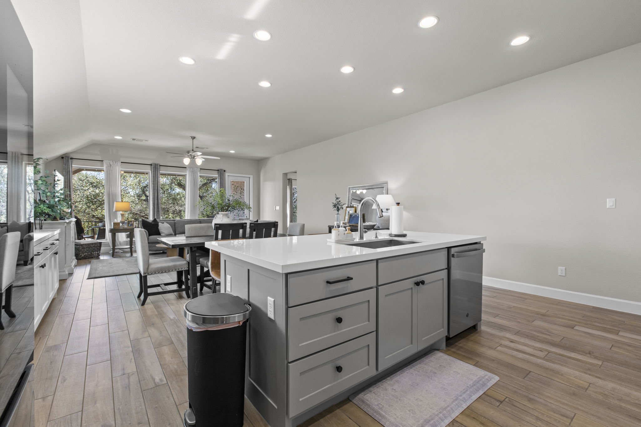 313 Terrene Trail Georgetown, TX 78628 - Photo 40 of 40 Kitchen featuring recessed lighting, open floor plan, light wood-style flooring, a kitchen island with sink, and gray cabinets