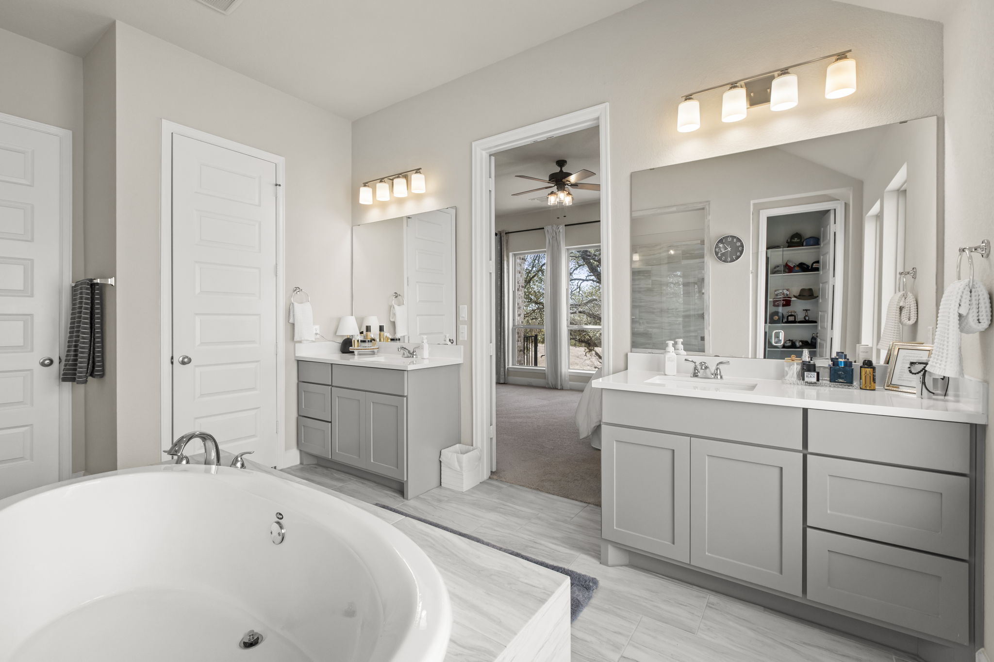 313 Terrene Trail Georgetown, TX 78628 - Photo 16 of 40 Bathroom with two vanities, a freestanding tub, tiled shower, a ceiling fan, and a spacious closet