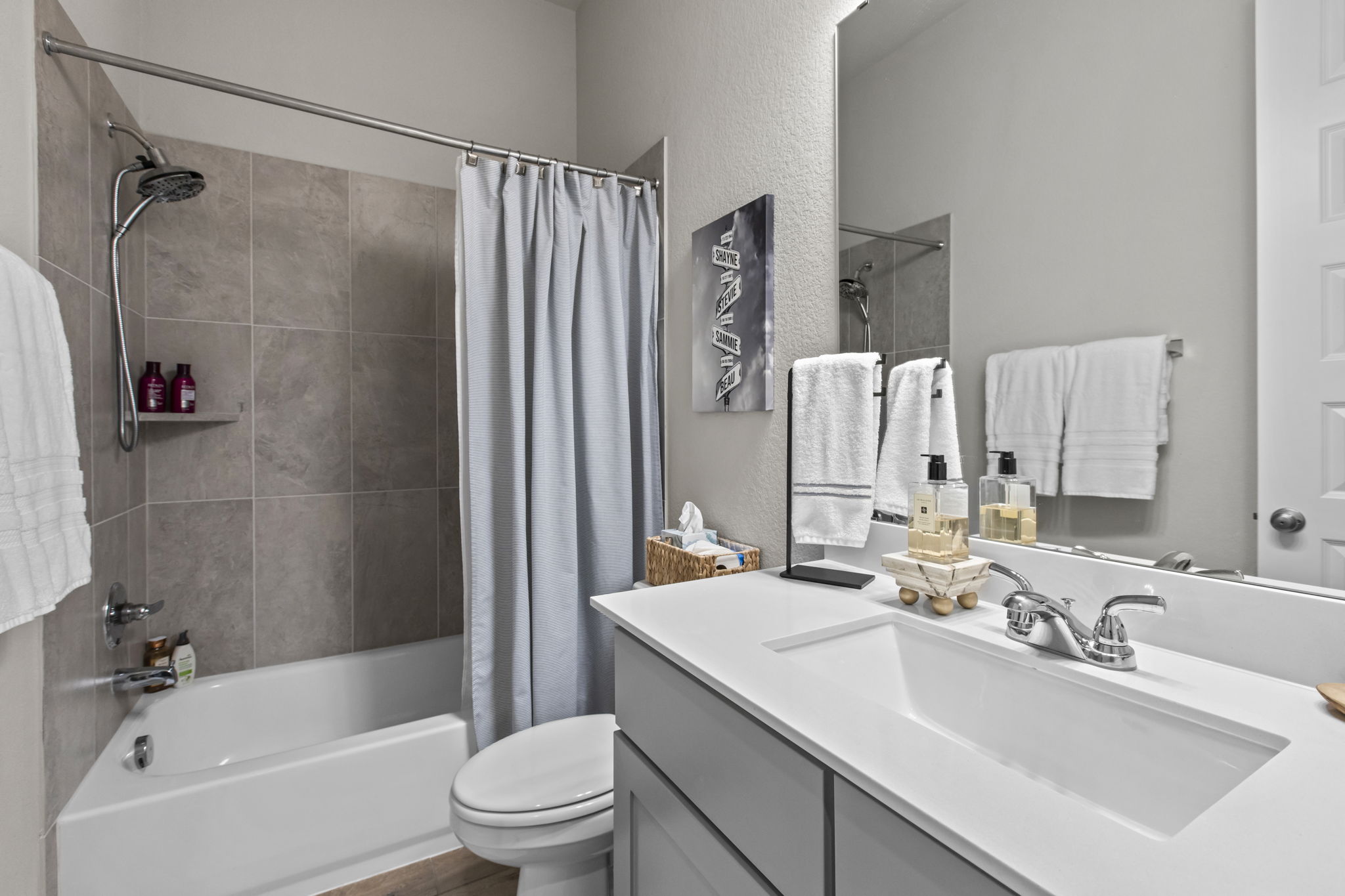 313 Terrene Trail Georgetown, TX 78628 - Photo 27 of 40 Bathroom featuring vanity, shower / bath combo with shower curtain, and a textured wall