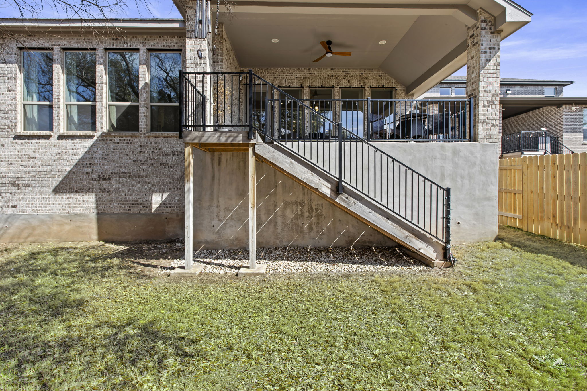 313 Terrene Trail Georgetown, TX 78628 - Photo 35 of 40 View of exterior entry with a ceiling fan, brick siding, a patio, and a lawn