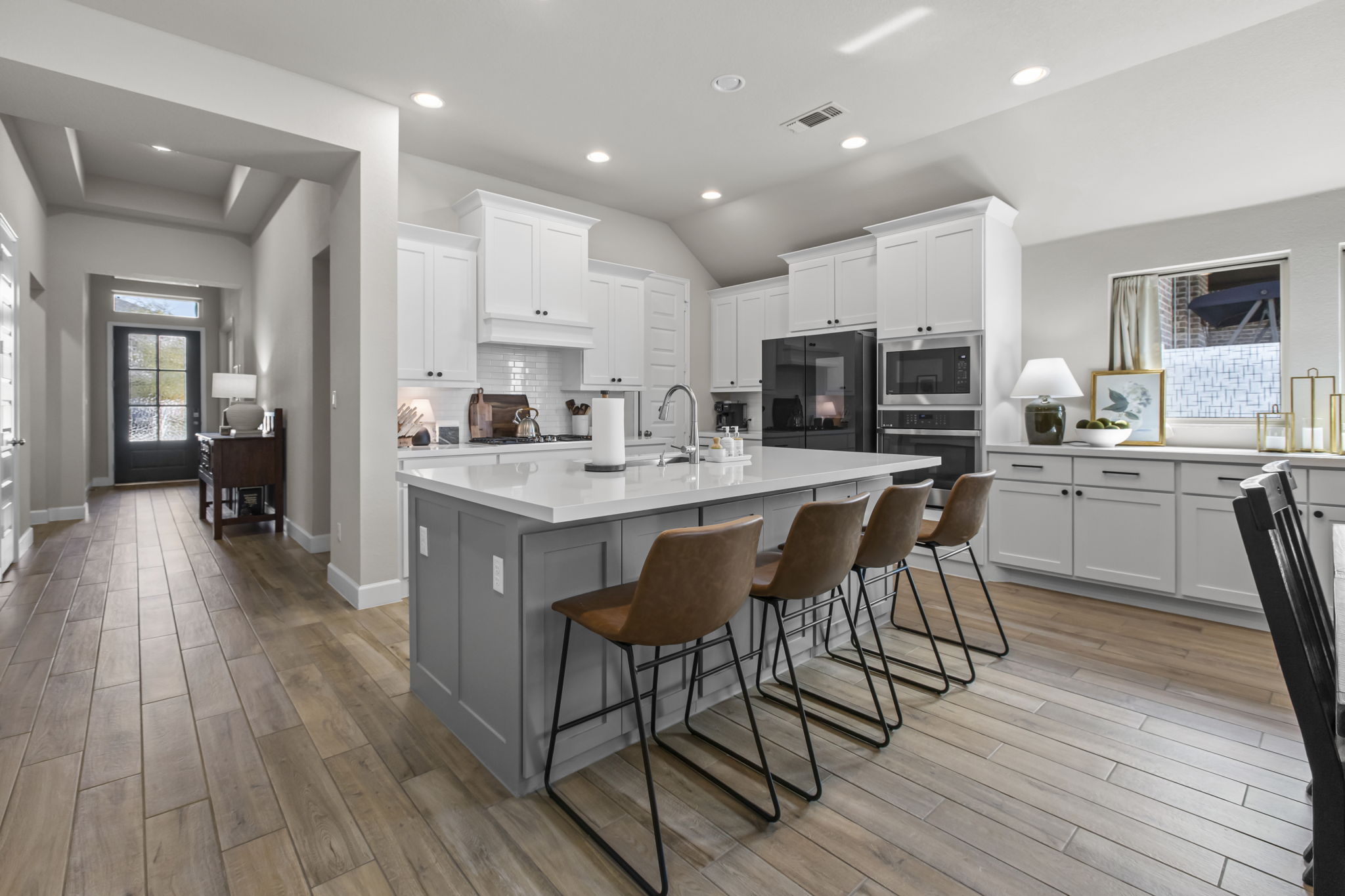 313 Terrene Trail Georgetown, TX 78628 - Photo 6 of 40 Dual tone kitchen featuring a kitchen breakfast bar, a kitchen island with sink, light wood finished floors, stainless steel appliances, and recessed lighting