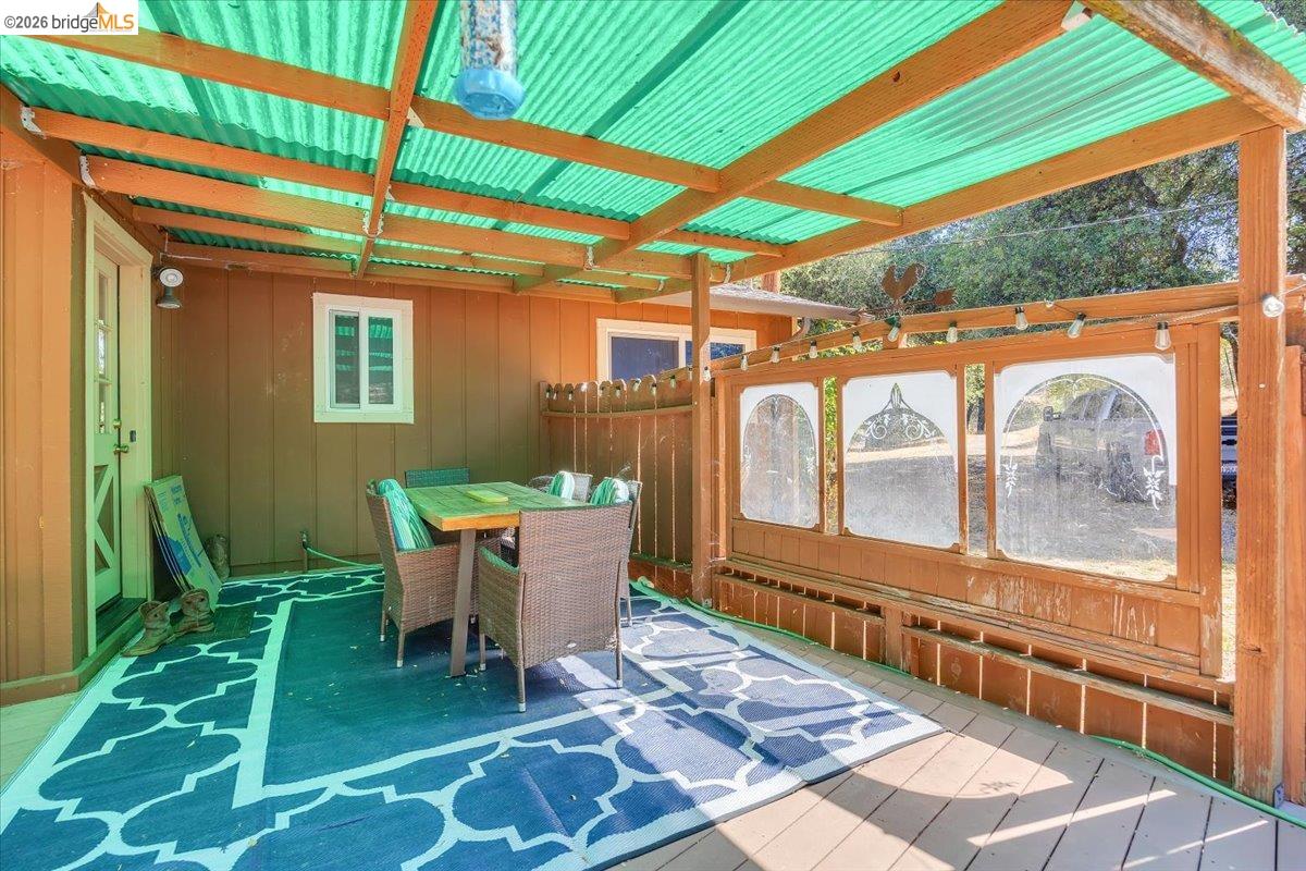 8733 Fraguero Road Sonora, CA 95370 - Photo 63 of 73 Exterior patio featuring a wood-plank deck, transparent green corrugated roof, and brown siding