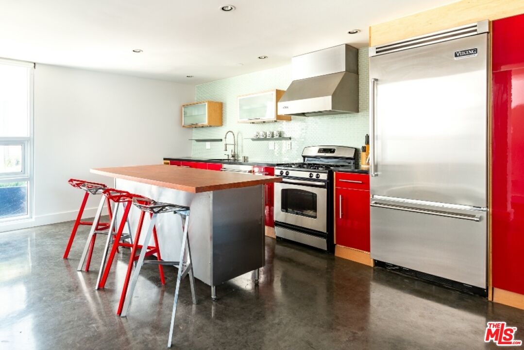 615 Hampton Drive, Unit A109 Venice, CA 90291 - Photo 2 of 12 a utility room with stainless steel appliances granite countertop a stove and a refrigerator
