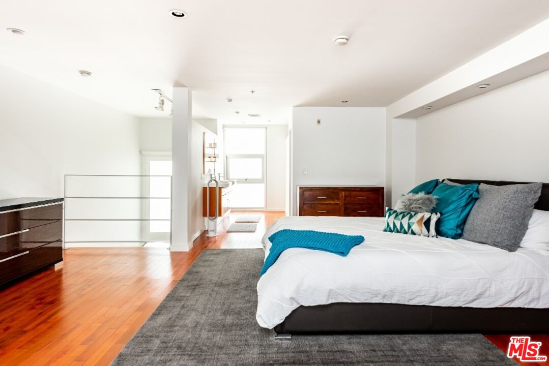 615 Hampton Drive, Unit A109 Venice, CA 90291 - Photo 9 of 12 a bedroom with a bed and wooden floor