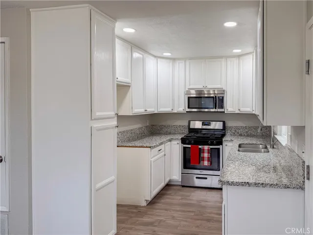 a kitchen with stainless steel appliances granite countertop a sink and a stove