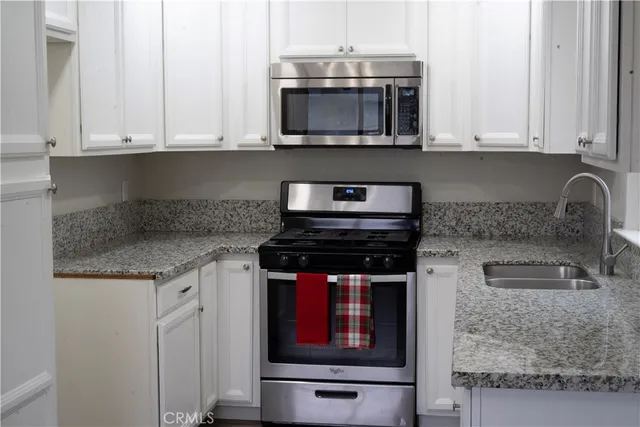 a kitchen with stainless steel appliances granite countertop a stove and a microwave