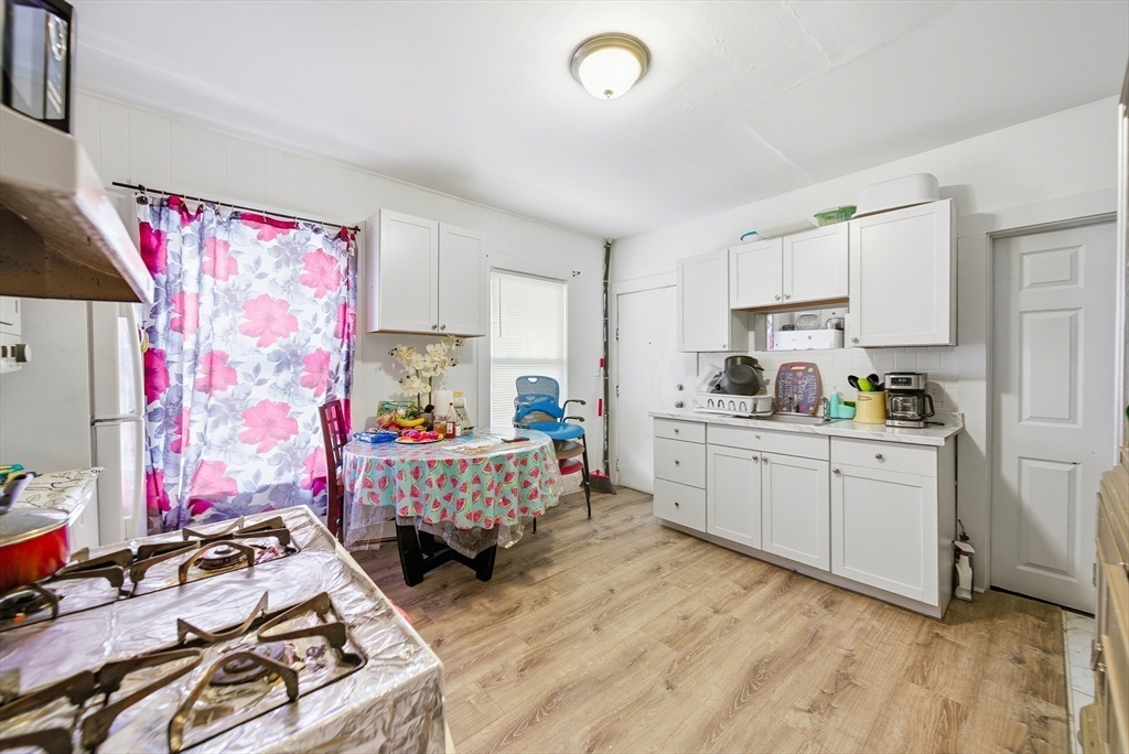 94 Sheridan Street Lynn, MA 01902 - Photo 12 of 33 a kitchen that has a lot of white cabinets and wooden floor