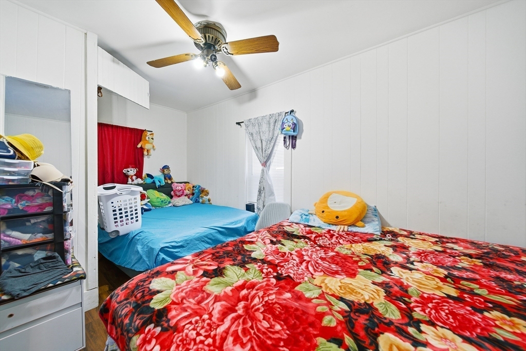 94 Sheridan Street Lynn, MA 01902 - Photo 14 of 33 a bedroom with a bed a dresser and potted plants
