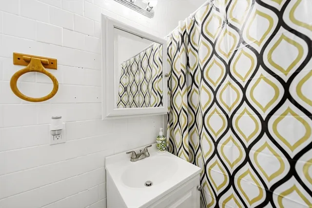 a bathroom with a sink a mirror and a shower curtain
