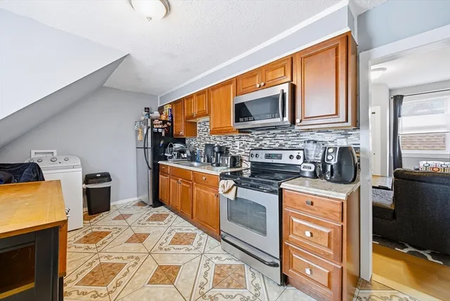 a kitchen with stainless steel appliances granite countertop a stove top oven a sink dishwasher and cabinets with wooden floor